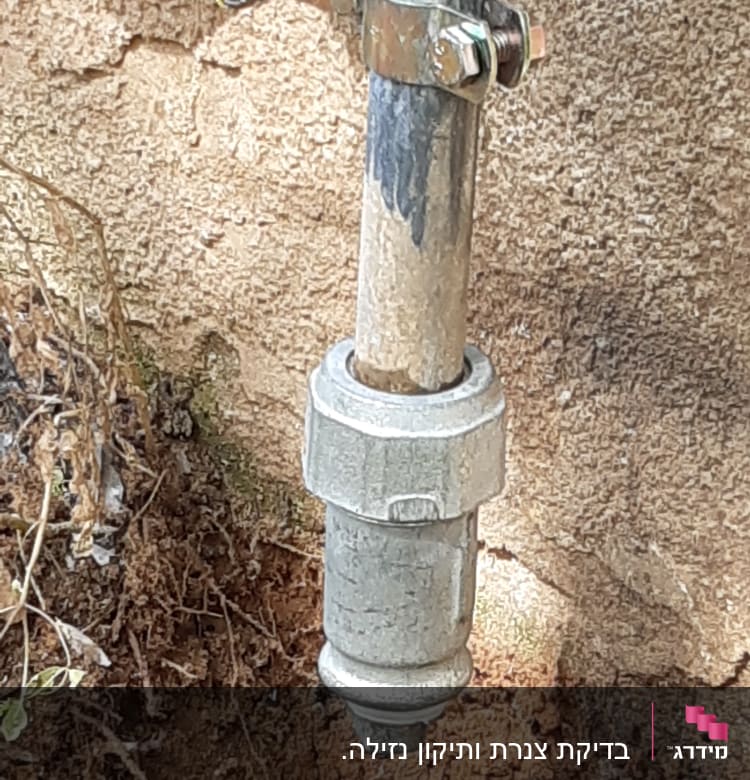 צינור מתכת עם חיבורי ברגים על קיר